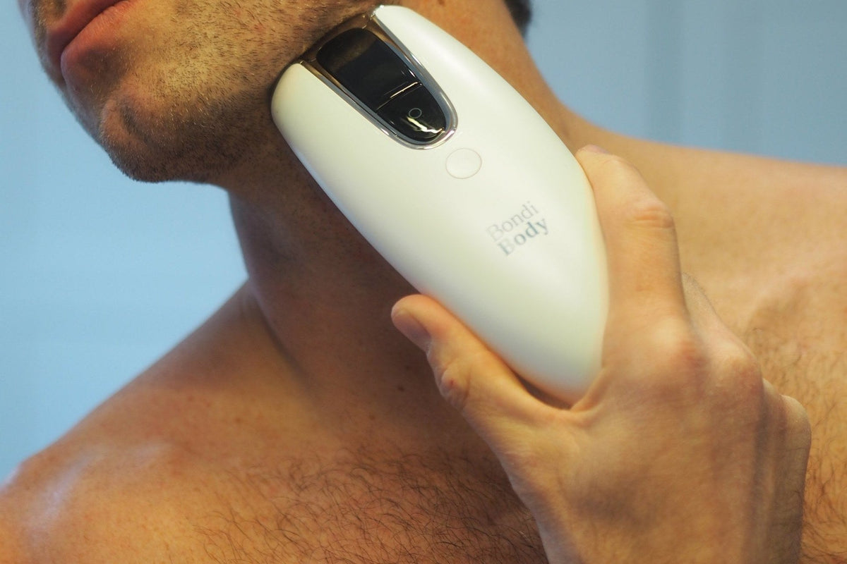 Man with chest hair holding the Bondi Body V2 IPL device