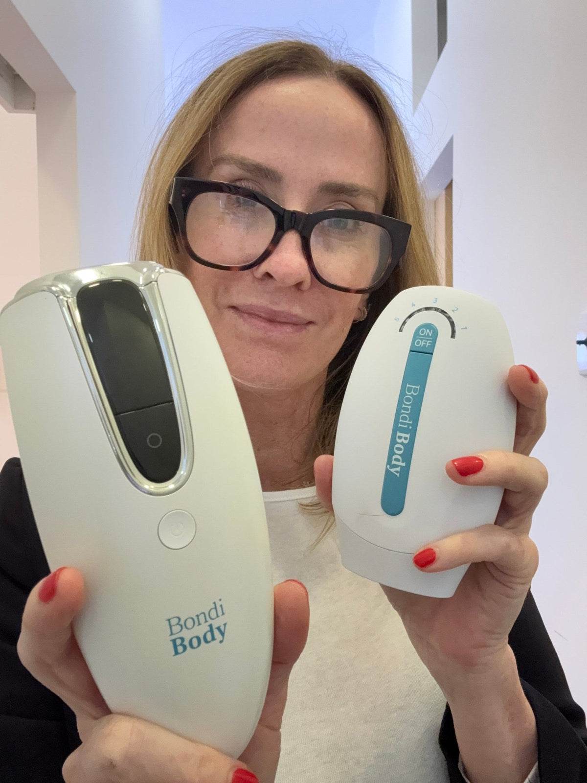 Trish, founder of Bondi Body, holding the Bondi Body V2 and Mini IPL devices