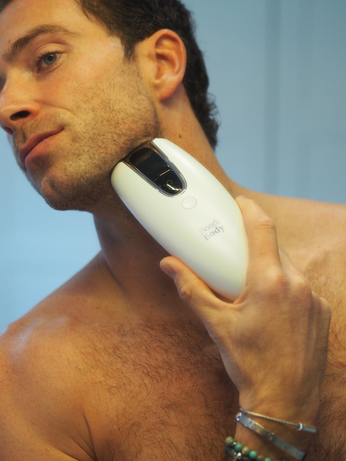 Man using the Bondi Body V2 IPL device on his jawline and neck